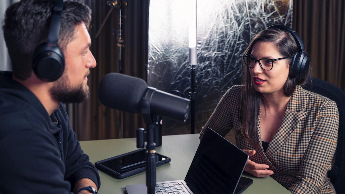Un hombre y una mujer con auriculares conversan ante un micrófono de podcast en un estudio con paneles acústicos